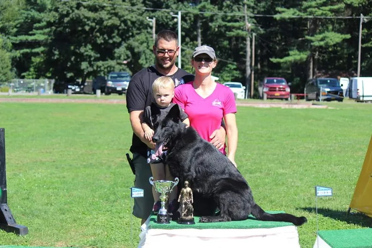 Scott, Lindsey and Abigail with their German Shepherd and trophies at a working-dog event